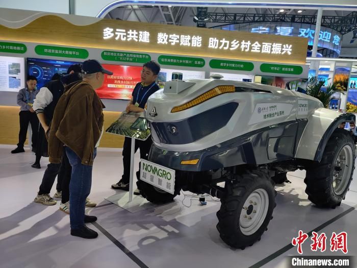 图为：新能源无人驾驶拖拉机吸引众多参观者驻足拍照。　叶秋云 摄