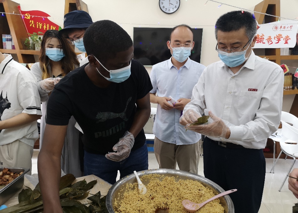 吴建平校长与安哥拉学生卫宇达包粽子.jpg